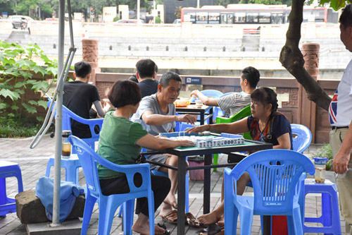 Chengdu locals enjoy their leisure by playing mahjong outside.